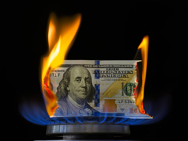 Dollar bill on fire in gas burner flame. Gas burner burning one hundred dollar bill. Aflame stock pictures, royalty-free photos & images