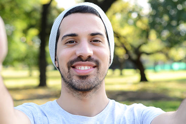 istock Young latin man taking a selfie in a park. 542016530
