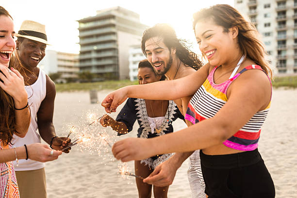 istock friends using a sparkler togetherness on the beach 542065278