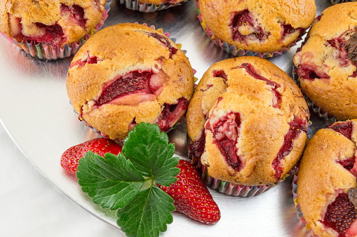 Strawberry muffins on a plate with fresh strawberry fruit