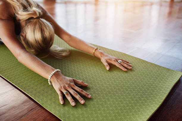 female doing stretching workout on exercise mat - yoga meditating women exercise mat imagens e fotografias de stock