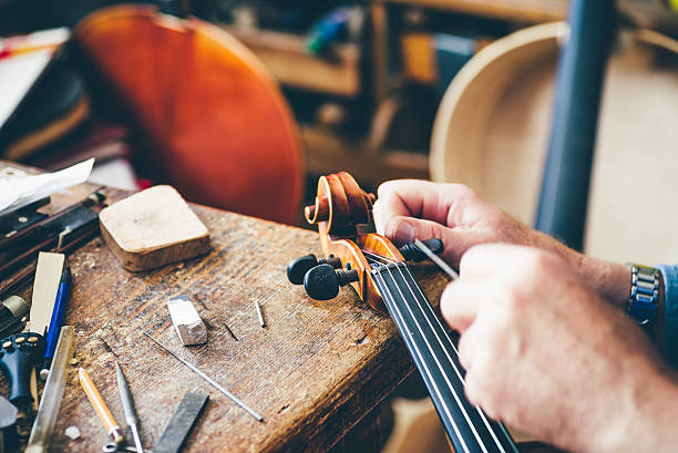 luthier repara violín en su taller - fabricante de instrumentos fotografías e imágenes de stock