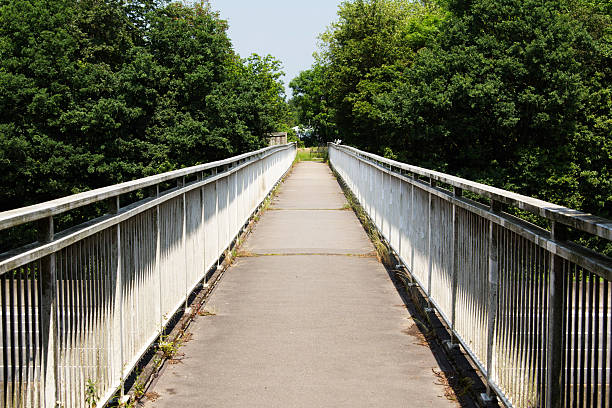 istock View along a long footbridge with railings on either side 542068772