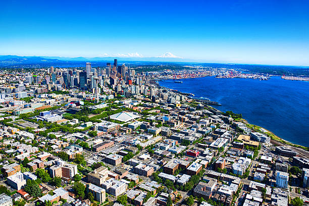 Distant Aerial View of the Seattle Skyline and Metro Area The beautiful distant skyline of Seattle, Washington shot from an altitude of approximately 800 feet during a helicopter photo flight on a sunny summer afternoon. puget sound aerial stock pictures, royalty-free photos & images