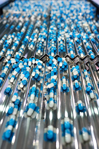 Capsule Production Line Close-up of the capsule in production line. pharma herbal medicine pill medicine stock pictures, royalty-free photos & images