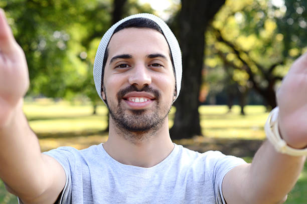 istock Young latin man taking a selfie in a park. 542078020