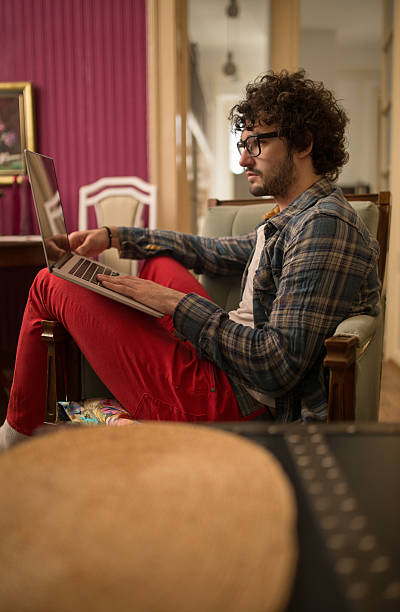 istock Side view of young man surfing the net on laptop. 542080636