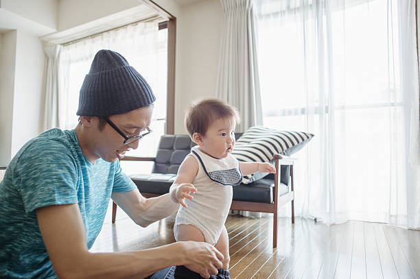 istock Father changing baby's clothes at home. 542080818