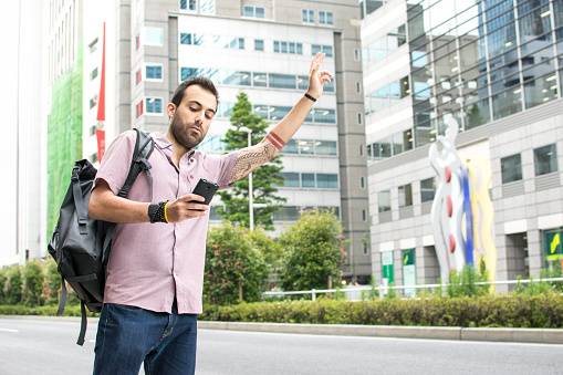 Blanco hombre joven sosteniendo un teléfono celular llamar Taxi Uber photo