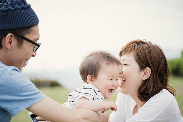 Asian parents having a good time with cute baby boy on holiday.
