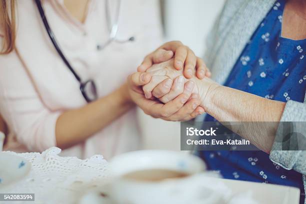 Social Worker Is Visiting A Senior Woman Stock Photo - Download Image Now - Embracing, Patient, Senior Adult