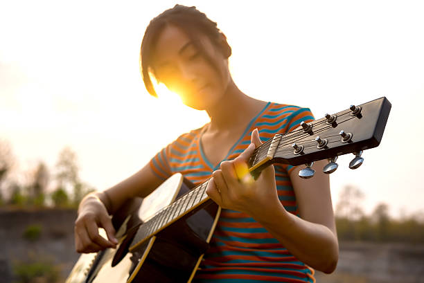 Young Woman's Hand Playing guitar. outdoors stock photo