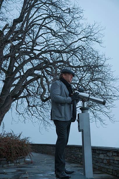 man standing with a telescope - street fog profile imagens e fotografias de stock