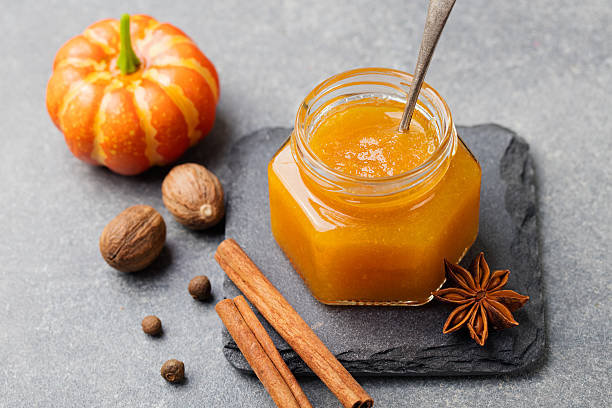 confiture de abóbora, geleia, molho com especiarias na mesa de pedra - gelatin dessert orange fruit marmalade - fotografias e filmes do acervo