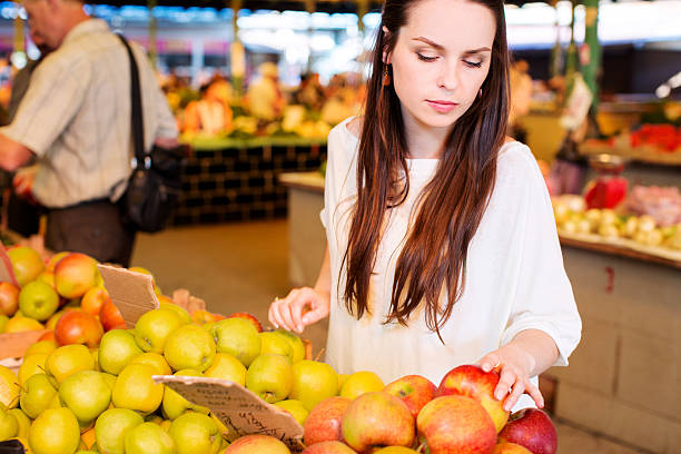 istock Beautiful brunette woman choosing red apples 542087366