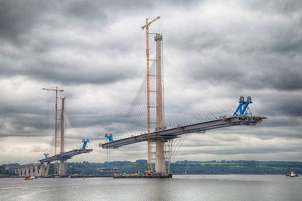 le nouveau queensferry traversée en forme sous le ciel nuageux - rivière firth of forth photos et images de collection