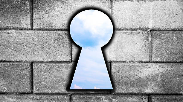 istock blue sky after key hole in aged brick wall background 542091536