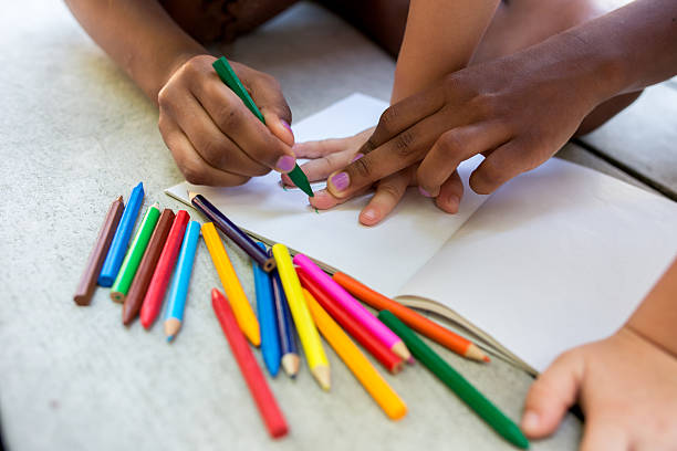 istock Hands of creative children coloring on paper with crayons. 542092140