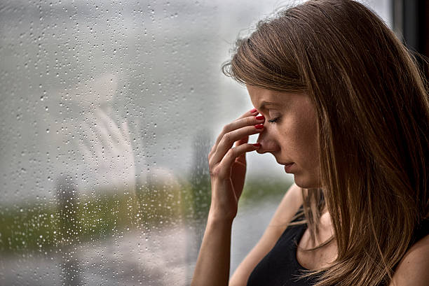 Woman Next To The Window On A Rainy Day Stock Photo - Download Image Now -  Rain, Headache, Women - iStock