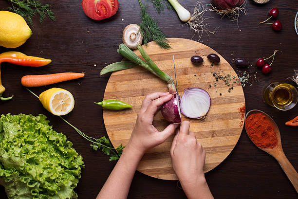 istock Human hands slicing onion on the cutting board 542100698