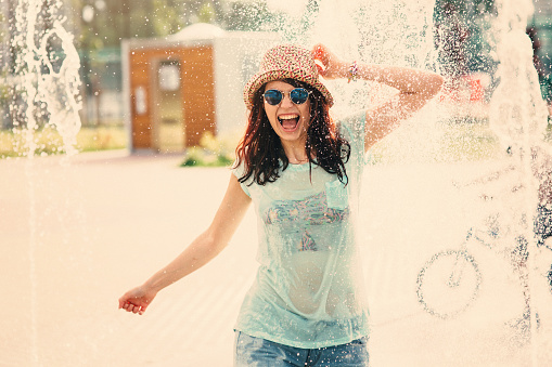 Girl having fun in a water fountain.