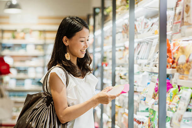 donna di mezza età acquisto di generi alimentari al supermercato - yagi foto e immagini stock