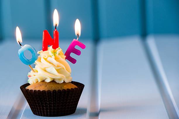 cupcake with a candles for 1 - first birthday - cupcake birthday birthday cake first place imagens e fotografias de stock