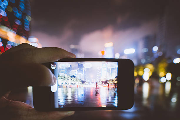istock using cell phone take photo at city night 542104332
