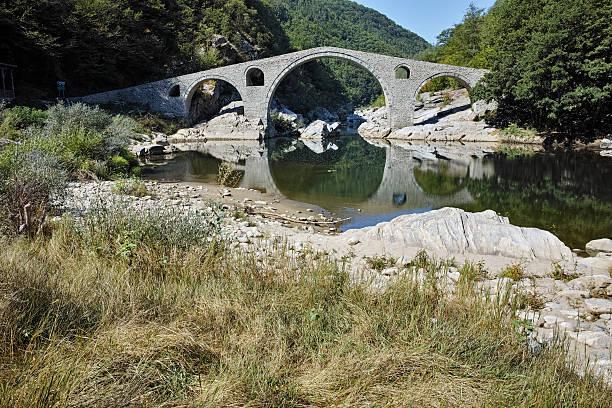 istock Reflection of Devil's Bridge and Rhodopes mountain in Arda river 542104572