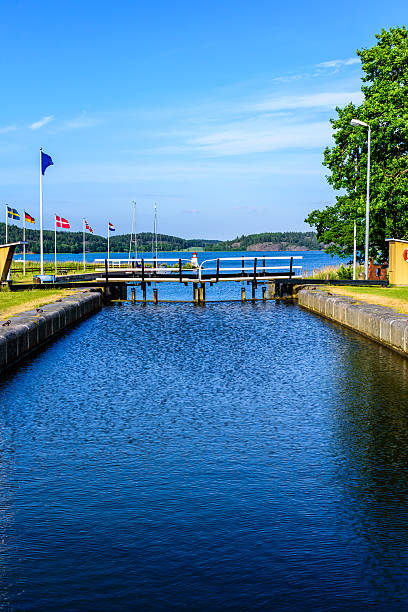 Canal locks Closed canal lock gate with the Baltic sea behind. Fine summer weather. Sailing boats moored in background. Different water level on either side of the sluice gate. Gota canal at Mem, Sweden. ostergotland stock pictures, royalty-free photos & images