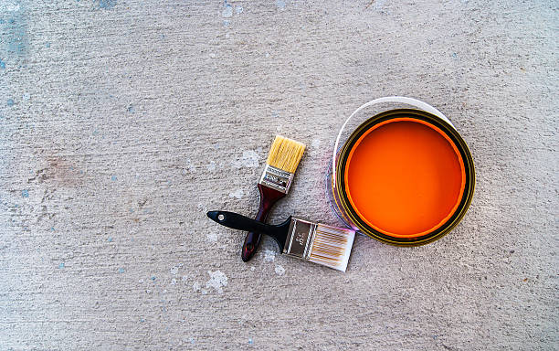 istock paint brush with open color can on cement floor 542106918