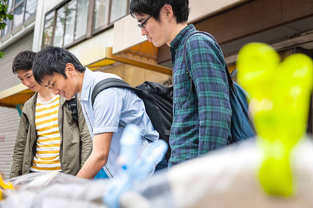 estudiantes japoneses de la clase de verificar libros en la calle en kyoto, japan - checking for rain fotografías e imágenes de stock