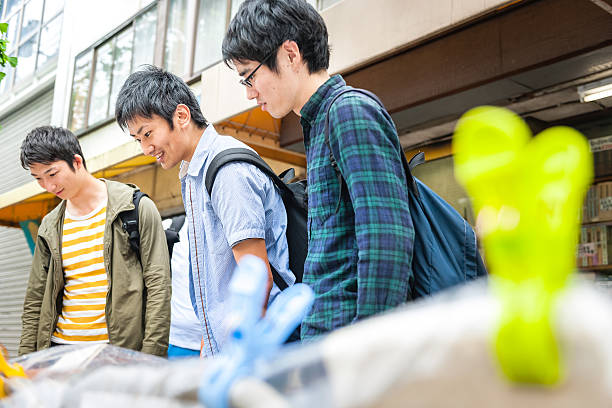 estudiantes japoneses de la clase de verificar libros en la calle en kyoto, japan - checking for rain fotografías e imágenes de stock