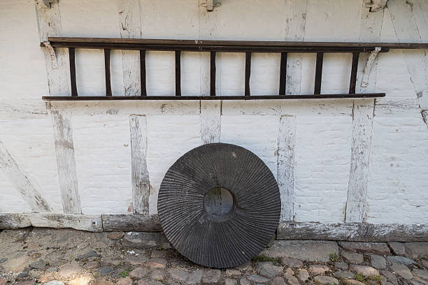 A Old millstone leaning on a wall