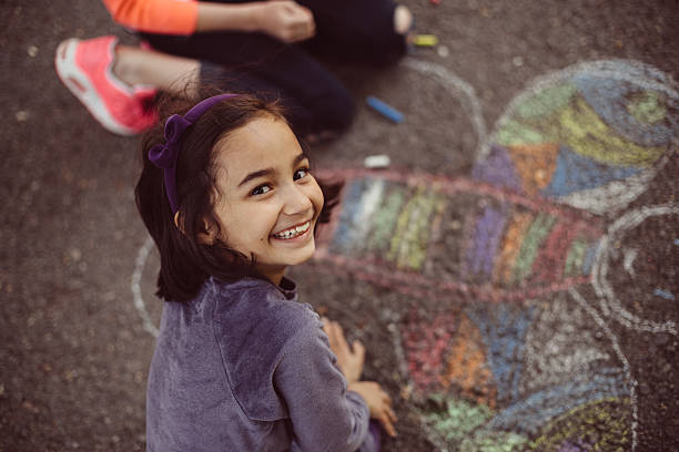 los niños de dibujo con tiza en cemento - little girls sidewalk child chalk fotografías e imágenes de stock