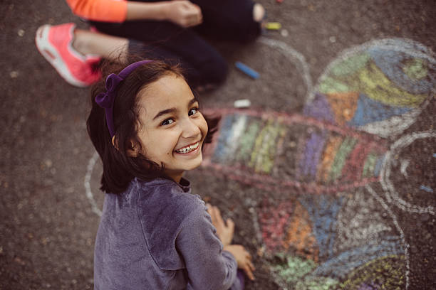 Kids drawing with chalk on asphalt Happy kids drawing on the ground playground photos stock pictures, royalty-free photos & images