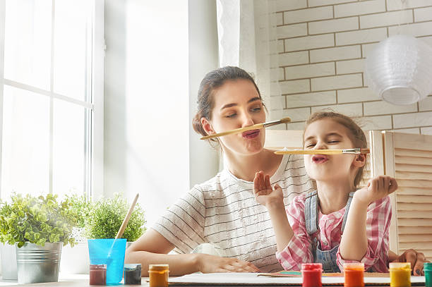 Mother and daughter together paint Happy family. Mother and daughter paint together and fooling around. child paintbrush stock pictures, royalty-free photos & images