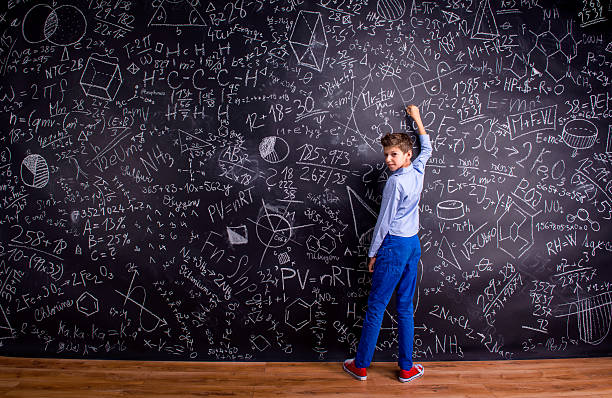 istock Boy against big blackboard with mathematical symbols and formula 542170914