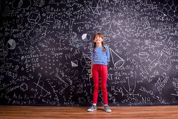 istock Girl with two braids, big blackboard with mathematical symbols 542171414