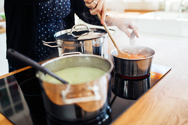 femme faisant le déjeuner dans la cuisine - making soup photos et images de collection
