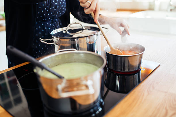 Woman making lunch in kitchen Woman making lunch in kitchen and stirring soup happy green peas stock pictures, royalty-free photos & images