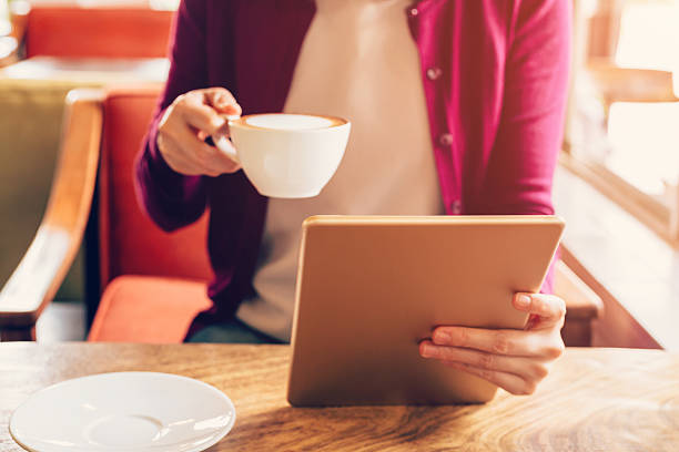 istock Woman hands using and holding  computer tablet in coffee shop 542172078