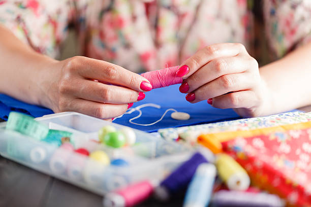 istock Closeup of woman hands sewing a button 542173552