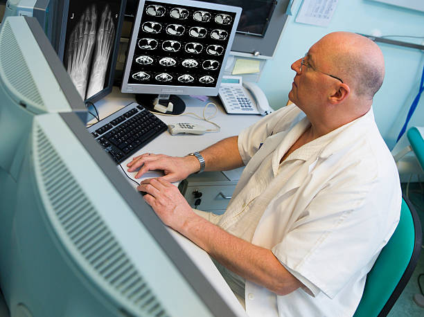 senior radiologue d'oncologie institute est examing numérisées à résonance magnétique - pancréas humain photos et images de collection