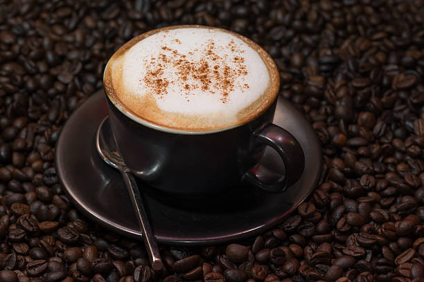 istock cappuccino coffee over roasted coffee beans as background 542176286