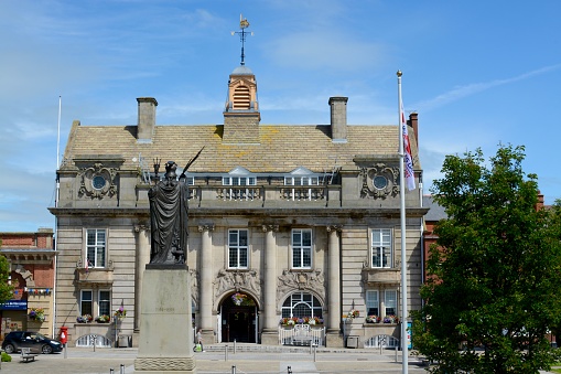 Crewe, United Kingdom - June 23, 2016: Crewe town hall / municipal building and war memorial, one member of the public can be seen in a car and one more walking, Crewe, Cheshire, UK 