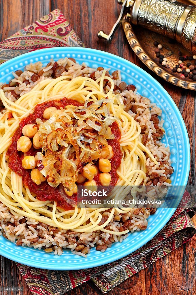 Kushari - Egyptian dish of lentils, rice, pasta, chickpeas Kushari - Egyptian dish of lentils, rice, pasta, chickpeas with tomato sauce and crispy onions Chick-Pea Stock Photo