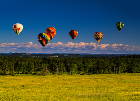 Scenic aerial view of red hot air balloon above the valley