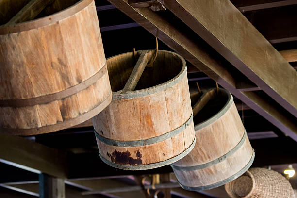 Set of wooden barrels with lids for storing white liquid. Stored on beaten earth.