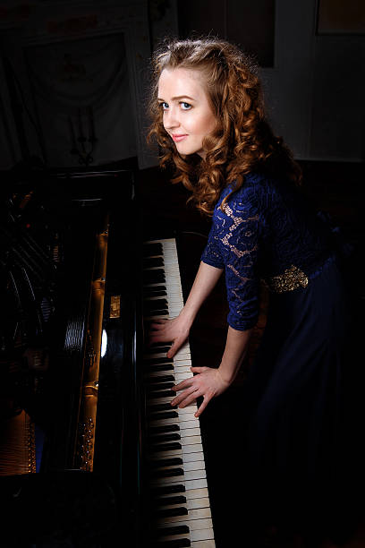 istock Young woman playing the grand piano 542186902